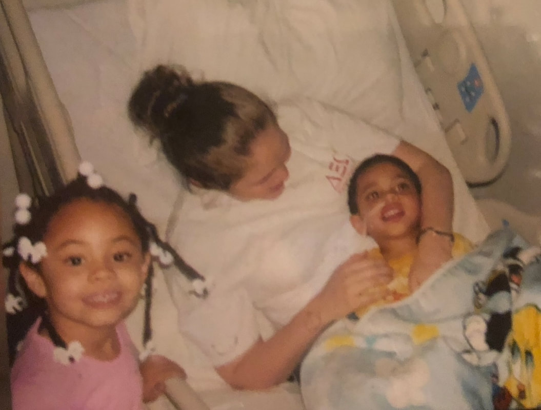 Picture of Two sisters and brother in hospital bed.