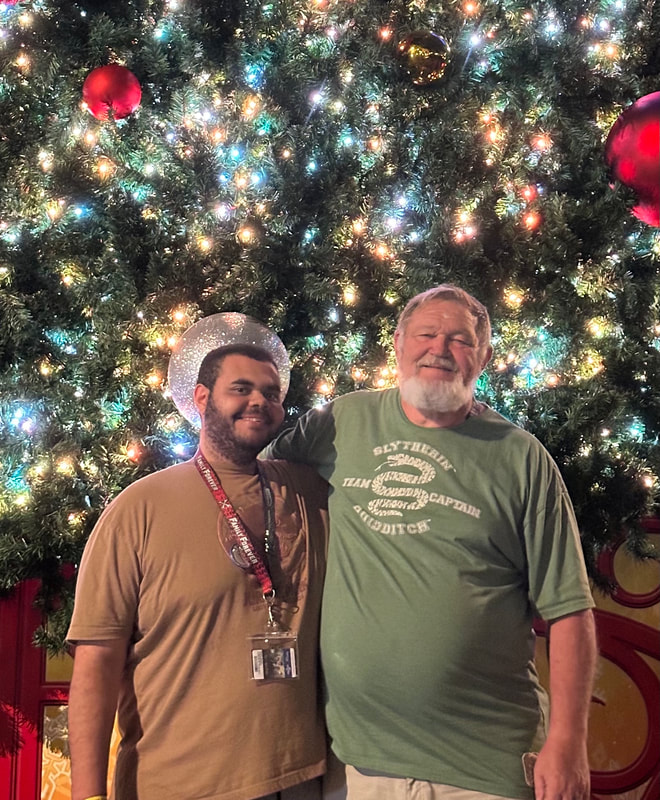 Picture of My husband and youngest son in front of Christmas Tree