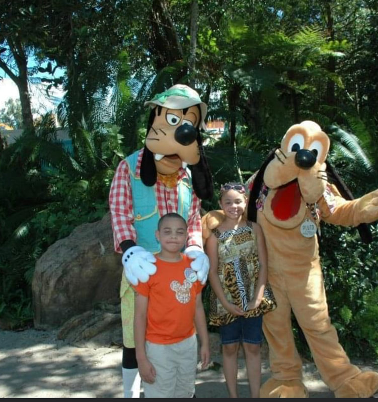 Picture of two kids with Goofy and Pluto at AK in WDW