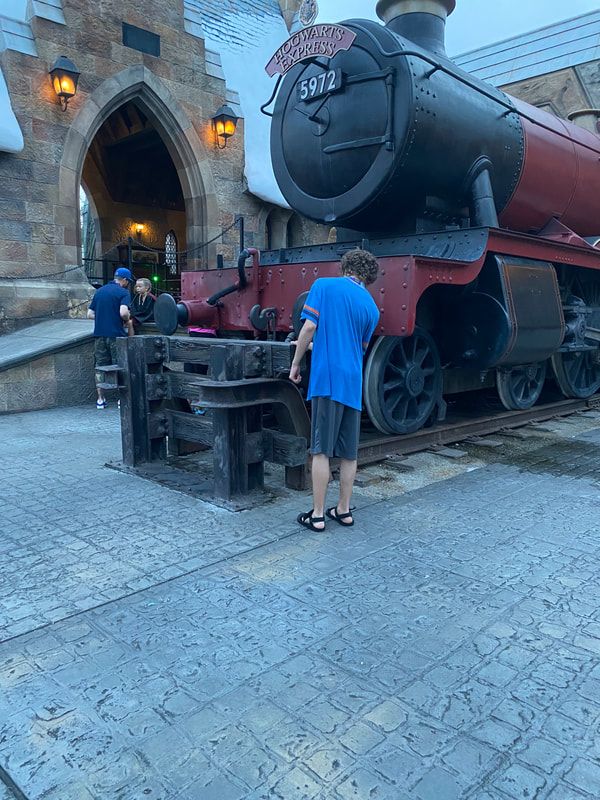 Picture of someone taking the time to explore the details of Hogwarts Express engine in Hogsmeade at Universal Orlando